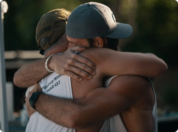 Andrew Schultz embracing a participant at a Positive Impact retreat